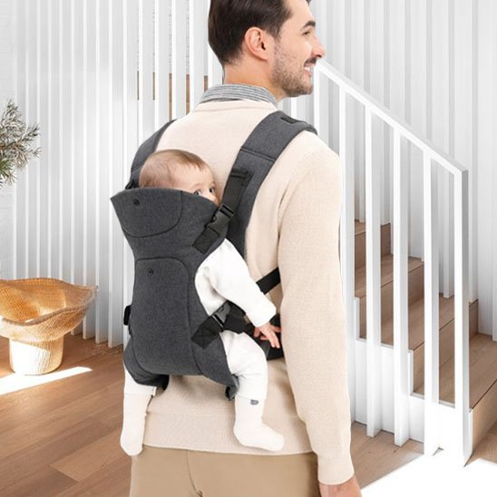 bebe dans le porte bebe au dos de son pere pret a monter l'escalier