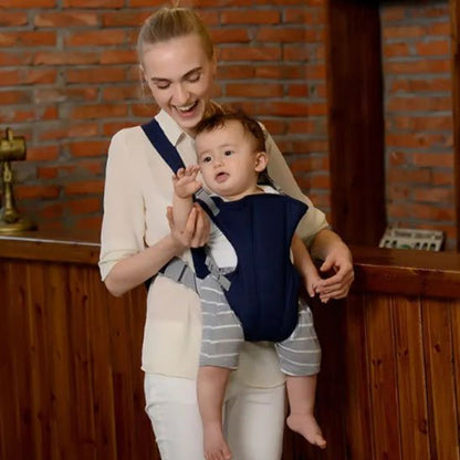 bébé dans son Porte bébé qui souris en jouant avec sa maman